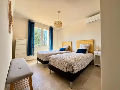 a bedroom with two beds and a window at Maison avec piscine chauffée, centre village in Saint-Saturnin-les-Apt