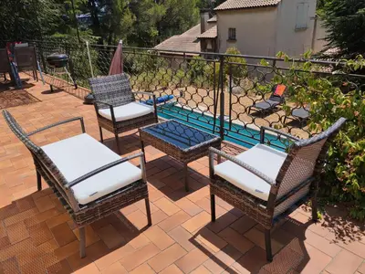 a patio with three chairs and a swimming pool at Maison avec piscine chauffée, centre village in Saint-Saturnin-les-Apt