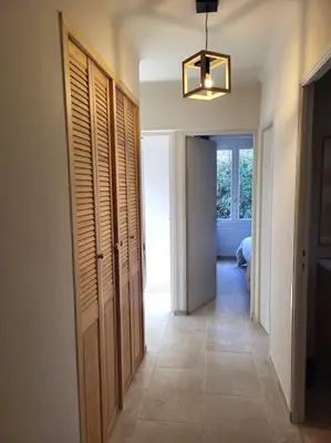 a hallway with wooden doors and a light fixture at Maison avec piscine chauffée, centre village in Saint-Saturnin-les-Apt