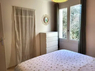 a bedroom with a bed with a dresser and a window at Maison avec piscine chauffée, centre village in Saint-Saturnin-les-Apt