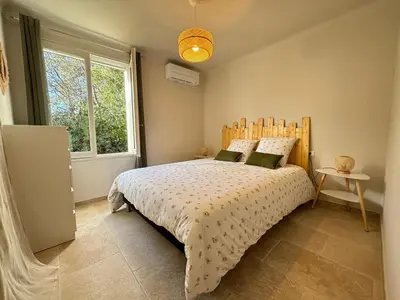 a bedroom with a bed and a large window at Maison avec piscine chauffée, centre village in Saint-Saturnin-les-Apt