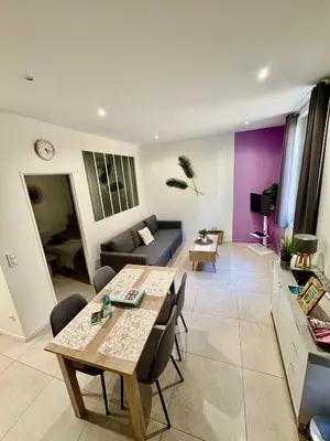 a living room with a table and a couch at Escapades L'Isloises au cœur de L'Isle-sur-la-Sorgue. in LʼIsle-sur-la-Sorgue
