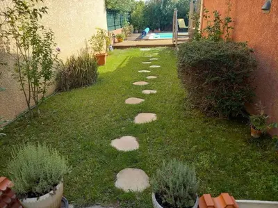 a garden with stepping stones in the grass at Les Myosotis Cavaillon/Petit Luberon in Cavaillon