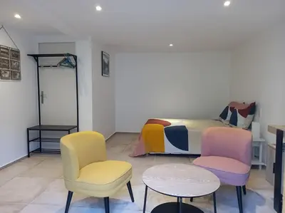a bedroom with a bed and two chairs and a table at Les Myosotis Cavaillon/Petit Luberon in Cavaillon