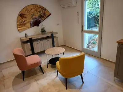 a living room with a table and two chairs and a table and a tablektop at Les Myosotis Cavaillon/Petit Luberon in Cavaillon