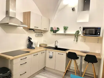 a kitchen with white cabinets and a counter with stools at *Le Lotus*Fiber Wifi*Hyper Center* in Salon-de-Provence
