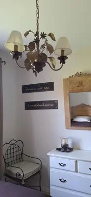 a room with a chandelier and a chair and a dresser at Cherche Midi in Noves