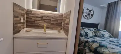 a bathroom with a sink next to a bed at LES BOIS DE ZOLA entre Provence et Luberon in Saint-Estève-Janson