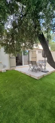 two chairs sitting under a tree in a yard at LES BOIS DE ZOLA entre Provence et Luberon in Saint-Estève-Janson