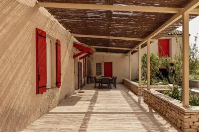 an internal courtyard of a house with red doors at La ferme du 645 in Entraigues-sur-la-Sorgue