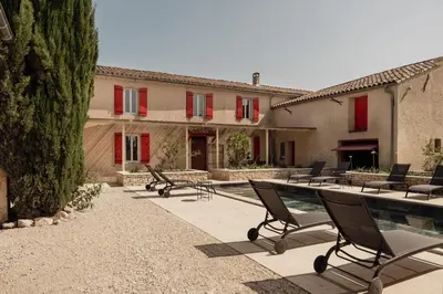 a patio with chairs and a pool in front of a house at La ferme du 645 in Entraigues-sur-la-Sorgue