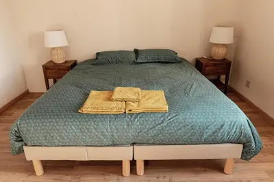 a bedroom with a bed with two towels on it at La ferme du 645 in Entraigues-sur-la-Sorgue