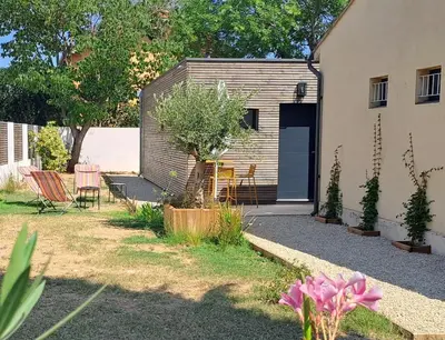 a backyard of a house with a garage at Gîte cosy et tout équipé 