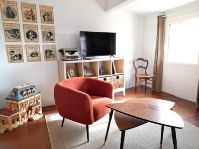 a living room with a chair and a table at L'atelier au coeur du village in Roussillon