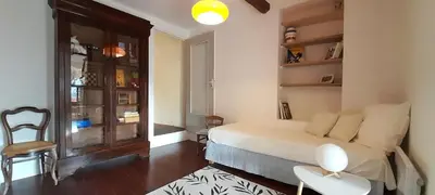 a bedroom with a bed and a table and a chair at L'atelier au coeur du village in Roussillon