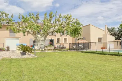 a large house with a tree in the yard at Le Petit Mas Rey in Eyragues