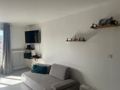 a living room with a couch and a flat screen tv at House of Essia in Aix-en-Provence