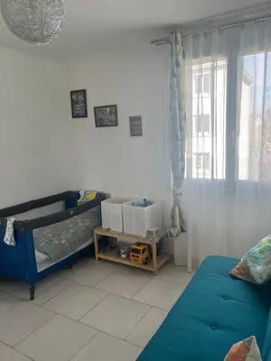 a living room with a blue couch and a window at House of Essia in Aix-en-Provence