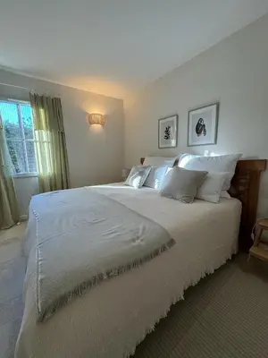 a bedroom with a large bed with white sheets and pillows at Maison d’Oléa in Bonnieux
