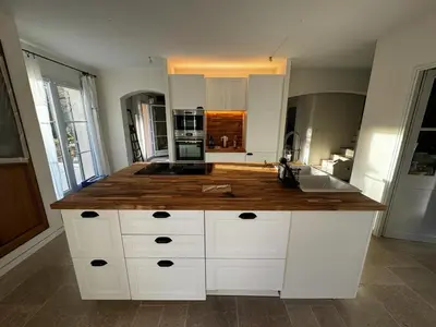 a large kitchen with a wooden counter top at Maison d’Oléa in Bonnieux