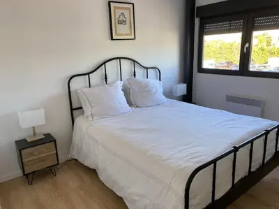 a bedroom with a bed with white sheets and a window at 