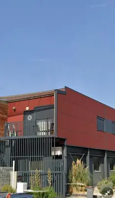 a red building with a fence in front of it at 