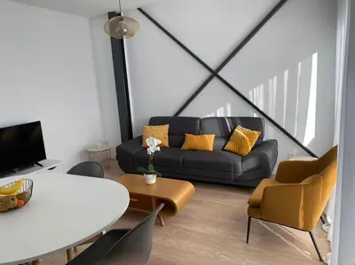 a living room with a black couch and yellow pillows at 