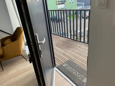 an open door to a balcony with a chair at 