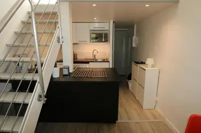 a kitchen with a staircase leading to a room with a kitchen at Le Gassendi Duplex in Aix-en-Provence