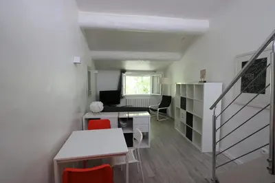 a room with a desk and a table with red chairs at Le Gassendi Duplex in Aix-en-Provence