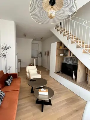 a living room with a couch and a staircase at La Collégiale in LʼIsle-sur-la-Sorgue