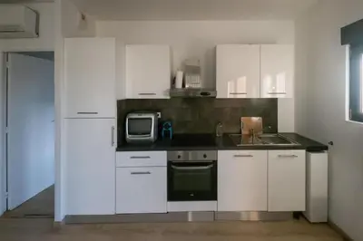 a kitchen with white cabinets and a sink and a microwave at 