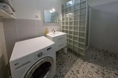 a bathroom with a washing machine and a sink at 
