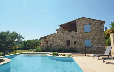 a swimming pool in front of a stone building at Amazing Home In Sainte Croix-À-Lauze in Sainte-Croix-à-Lauze