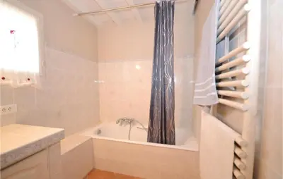 a bathroom with a tub and a shower curtain at Amazing Home In St Martin De Castillon in Saint-Martin-de-Castillon