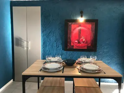 a wooden table with plates and wine glasses on it at Oustau Aix - Maison Odonata in Aix-en-Provence