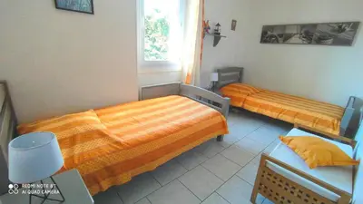 a bedroom with two beds and a window at Mas de St-Andiol in Cabannes