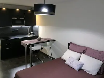 a bedroom with a bed and a kitchen with a table at STUDIO Mr&Mrs in Aix-en-Provence