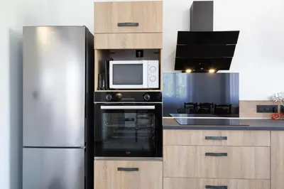 a kitchen with a stainless steel refrigerator and a microwave at L Orchidée in Mormoiron