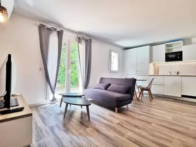 a living room with a couch and a table at Les quatre loges - joli t2 jardinet et parking *3 in Aix-en-Provence