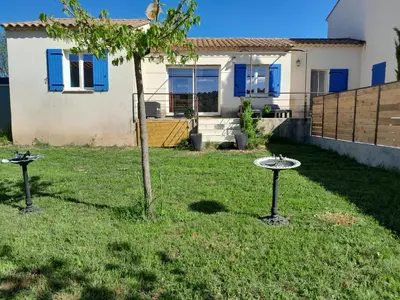 a yard with two bird stands and a tree at Sud luberon in Ansouis