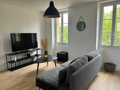 a living room with a couch and a flat screen tv at Havre de paix au sein d'un T3 d'une bastide aixoise in Aix-en-Provence