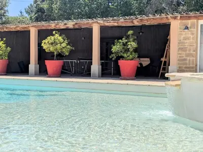 a swimming pool with two potted plants next to a building at L'Escargolette - Incroyable maison de vacances 4 étoiles in Carpentras