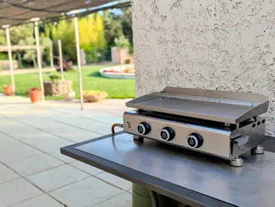 a grill sitting on a table next to a wall at L'Escargolette - Incroyable maison de vacances 4 étoiles in Carpentras