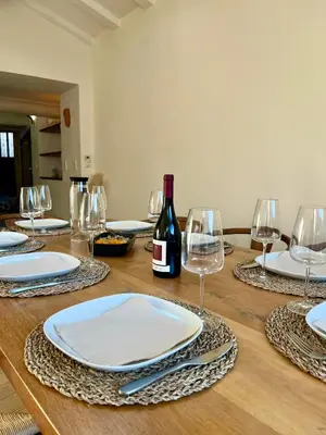 a wooden table with glasses and a bottle of wine at La Maison Jaune, une expérience inoubliable in Villes-sur-Auzon