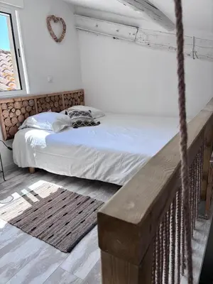a bedroom with a bed and a wooden bench at Appart Hôtel - Nature et Spa in Aurons