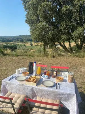 a table with plates of food on it in a field at Appart Hôtel - Nature et Spa in Aurons