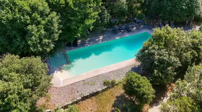 an overhead view of a swimming pool in a forest at Appart Hôtel - Nature et Spa in Aurons