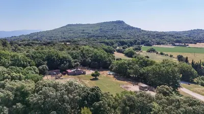 an aerial view of a farm with a mountain in the background at Appart Hôtel - Nature et Spa in Aurons