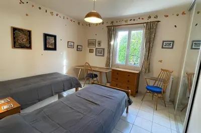 a bedroom with two beds and a table and a window at La Villa Tanamera, très jolie maison piscine, à 2 pas du centre-ville in Bédoin